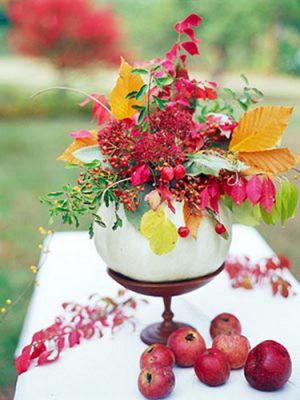 white pumpkin vase with fall leaves and apples