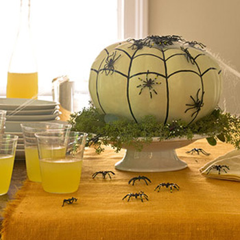 green pumpkin table centerpiece with black spiders for halloween party table decoration