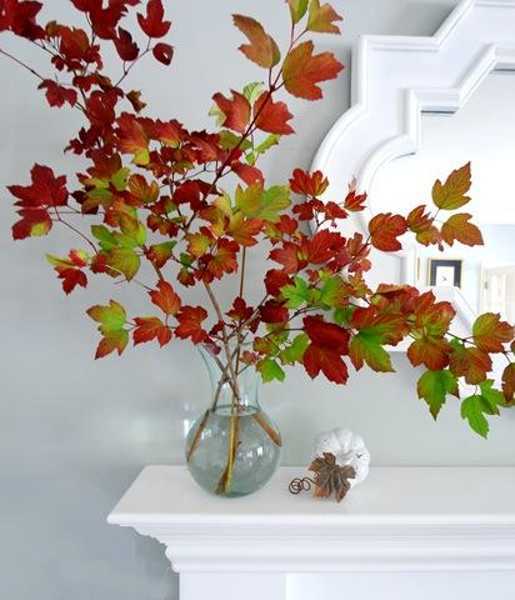 glass vase with fall leaves for fireplace mantel decorating