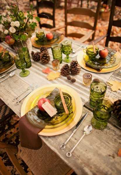 individual table centerpieces with brown napkins and red apples