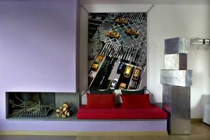 living room design with corner fireplace, steel sculpture, red sofa and large artwork