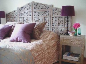 moroccan bedroom decorating with purple color and unique carved wood bed headboard