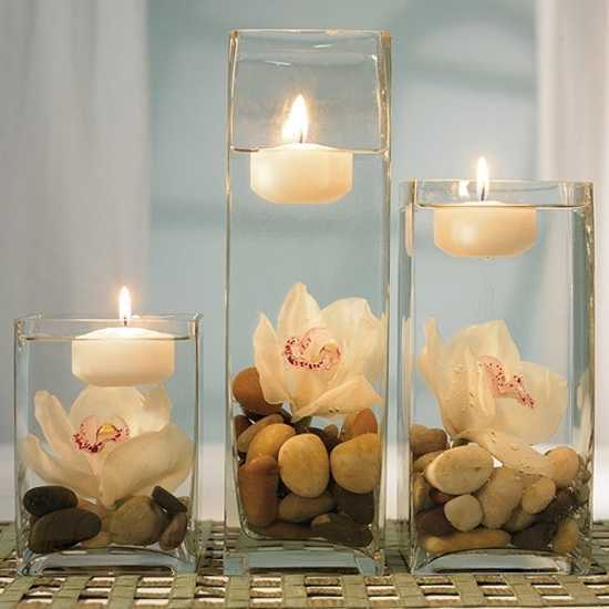 table centerpiece made with glass vases, tea candles and  river pebbles