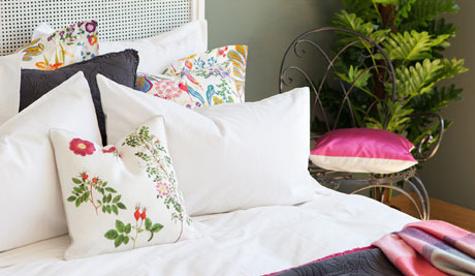 white bedding set with pillows in green and red colors